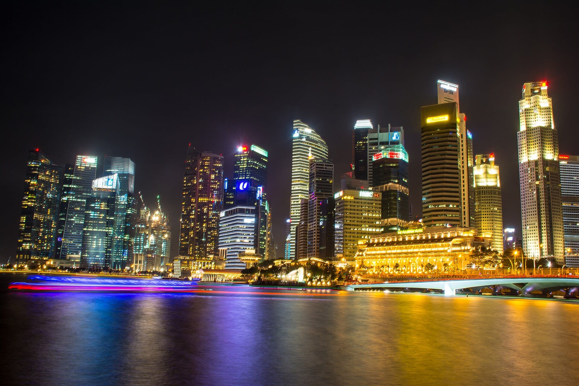 The Singapore Central Business District lit at night, seen across the water from the river mouth.